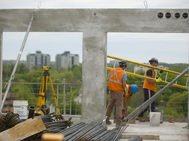 Helder Monez, using a drill, and Jonathan Camara brace a section of balcony wall while Marcello Ianni moves a ladder on the 10th floor of Tricar Group’s 24-storey Riverwalk residential tower being built on York Street just east of the Thames River in London. London’s apartment vacancy rate is low, as home prices keep more renters in place.  (MIKE HENSEN, The London Free Press)