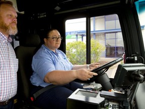 Kevin de Jeu, manager of driver training for the LTC watches as Yvonne Clark wheels an LTC bus around their Wonderland garage in London, Ont. Clark used to drive schoolbus and coaches for Greyhound, but says there is still a lot to learn about driving a city bus. (Mike Hensen/The London Free Press)