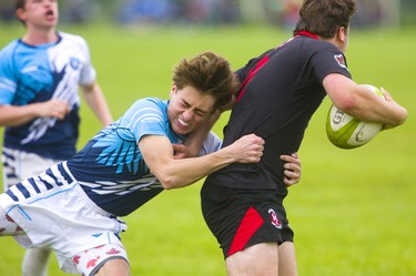 Lucas's Noah Dubroy tries to wrap up Medway's Brant Galbraith during the WOSSAA final in boys rugby held at St. George's Fields in London on Thursday. Medway, the No. 1 team in the province, wrapped up another WOSSAA championship 55-12, after a strong 43-0 first half set the tone of the game. Medway heads to OFSAA in Oshawa next week. (Mike Hensen/The London Free Press)