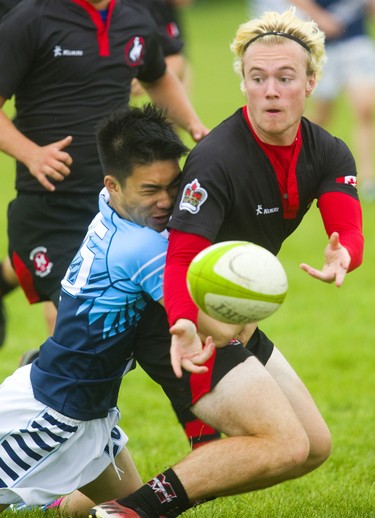 Lucas's Jason Huynh tackles Medway's Alistair Wotherspoon as Wotherspoon passes the ball to a teammate during the WOSSAA final in boys rugby held at St. George's Fields in London on Thursday. Medway, the No. 1 team in the province, wrapped up another WOSSAA championship 55-12, after a strong 43-0 first half set the tone of the game. Medway heads to OFSAA in Oshawa next week. (Mike Hensen/The London Free Press)