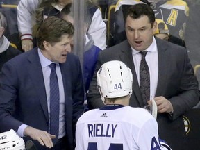 Toronto Maple Leafs head coach Mike Babcock, upper left, and assistant coach D.J. Smith talk with defenceman Morgan Rielly (44) on the bench during the third period of an NHL hockey game against the Boston Bruins, Saturday, Feb. 3, 2018, in Boston. (AP Photo/Mary Schwalm)