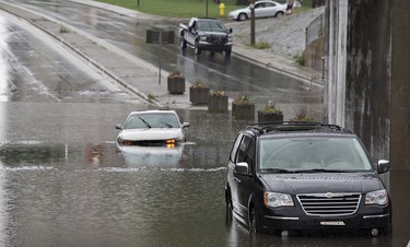 A heavy downpour just before 7:00 p.m. on Sunday June 14, 2015 flooded many underpasses in Brantford, Ontario including here at St. Paul Avenue near Brant Avenue.  The road was closed while vehicles were towed out and until water levels drained. Brian Thompson/Brantford Expositor/Postmedia Network