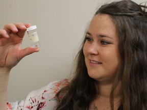 Jenna Armitage, a public health inspector in Lambton County, looks at a tick in a plastic vial. Public health officials in Ontario are urging residents to watch for and protect themselves from blacklegged ticks, and the Lyme disease they can carry.