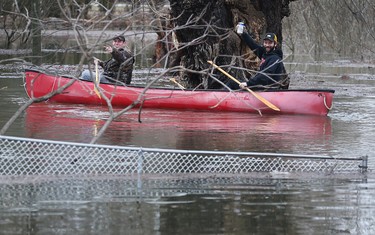 THAMESVILLE, ON. FEBRUARY 23, 2018. -- Robert Bellamy, left, and Shawn Ure were dealing with their backyard flood in Thamesville, ON. on Friday, February 23, 2018 in the most Canadian way possible, with a canoe and a cold one.(DAN JANISSE/The Windsor Star)