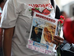 A woman holds a sign during the closing ceremony of the National Inquiry into Missing and Murdered Indigenous Women and Girls in Gatineau, Quebec, Canada, June 3, 2019. REUTERS/Chris Wattie