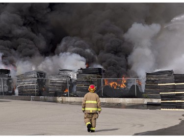 Stacks of rubber mats on skids burn in the yard at North West Rubber, located at 321 Henry Street in Brantford. Brantford Fire has been battling the blaze since about 6 a.m. Sunday, assisted by County of Brant Fire. Henry Street is closed from Plant Farm Road to just east of Wayne Gretzky Parkway. North West Rubber manufactures recycled rubber flooring. (Brian Thompson/Postmedia Network)