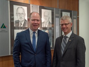 Jeff Macoun, president of Great-West Lifeco, and Richard Sifton, president of Sifton Properties, stand in front of a photo gallery of past JA London and District Business Hall of fame laureates. Macoun and Sifton were announced as the 2019 inductees Thursday. (MAX MARTIN, The London Free Press)