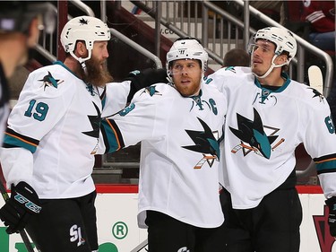 Joe Thornton #19, Joe Pavelski #8 and Justin Braun #61 of the San Jose Sharks celebrate after Pavelski scored a goal against the Arizona Coyotes during the third period of the NHL game at Gila River Arena on November 19, 2016 in Glendale, Arizona. The Coyotes defeated the Sharks 3-2 in overtime.