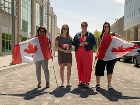 Members of the London Heritage Council and event organizers prepare for Canada Day London on Dundas Place. (MAX MARTIN, The London Free Press)