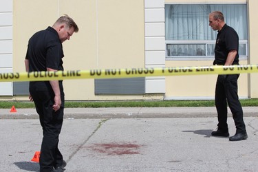 Forensic officers Sam Cook, left, and Paul Horenburg collect evidence from the scene of a shooting at the Ramada hotel at 817 Exeter Rd. in London on Monday, June 17, 2019. DALE CARRUTHERS / THE LONDON FREE PRESS