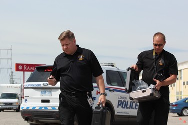 Forensic officers Sam Cook, left, and Paul Horenburg collect evidence from the scene of a shooting at the Ramada hotel at 817 Exeter Rd. in London on Monday, June 17, 2019. DALE CARRUTHERS / THE LONDON FREE PRESS