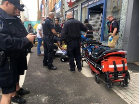 Emergency crews work to save a drug overdose victim who collapsed on Dundas Street in London this spring. A record 58 people died of opioid drug overdoses in the London area last year, with the crisis now turning up in courts across the region in tough charges against dealers whose drugs kill.  (DEREK RUTTAN, The London Free Press)