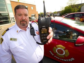 Deputy Fire Chief Jack Burt holds up a radio destined for fire prevention officers who often work alone in the field, in areas that could be hazardous as they inspect fire scenes. Burt says being alone, the inspectors need an instant way to communicate with the department in case of an emergency, (Mike Hensen/The London Free Press)