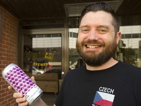 Nick Baird, one of the owners of Beerlab!, holds a can of Obi Porter outside their new location at 420 Talbot St. next door to  Milos' Craft Beer Emporium. (Mike Hensen/The London Free Press)