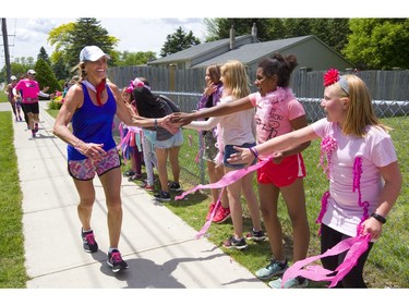 Pupils from Strathroy's  Mary Wright elementary school cheer on London cancer survivor Theresa Carriere near the midpoint of her 100-kilometre Onerun fundraising run for cancer care on Friday, June 14, 2019.  (Mike Hensen/The London Free Press)
