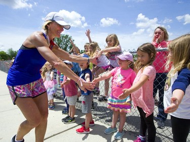 Theresa Carriere high-fives pupils from Strathroy's Mary Wright elementary school durng her 100-kilometre Onerun fundraiser for cancer care Friday. The Londoner's 100-kilometre trek takes her from London to Strathroy and back. (Mike Hensen/The London Free Press)