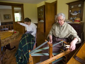 Patti Wilson and Betty Rolfe, dressed in period costumes, work on their mending and weaving Thursday, June 20, 2019 in the Jury homestead at the Fanshawe Pioneer Village in London. The village was founded in 1959 and is celebrating its 60th anniversary. (Mike Hensen/The London Free Press)