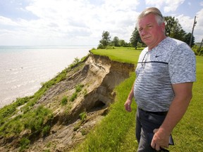 Kyle Cronk, president of Lake Erie North Shore Landowners Association, shows where his backyard is being eroded by high water into Lake Erie.   (Mike Hensen/The London Free Press)