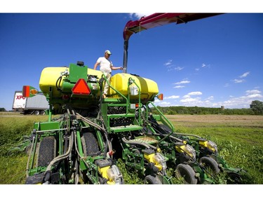 Randy Molzen of Oil Springs directs the auger into one of three seed containers on a large 40-foot planter. Molzen is having soybeans planted on his field, and since the season is running so late, hired a contractor with the big planter to get the fields done in a hurry.Many farmers in the region are just now finishing up planting soybeans, having given up on corn for the summer, due to the late planting window. Normally farmers hope to have their soybeans in by the May 24 weekend, so they're running about a month behind in the area. (Mike Hensen/The London Free Press)