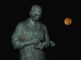 The Frederick Banting statue outside the Banting House museum is lit by the moon on Adelaide Street in London. (File photo)