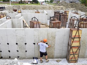 A worker with East Elgin Concrete Forming works on the foundation of a house in a new subdivision in Watford, the first major development in more than a decade for the small Lambton town. The 11-home subdivision, initiated when Warwick Township bought the long-vacant land, is expected to see new houses listed around $300,000 as early as this year. (Louis Pin/The Observer)