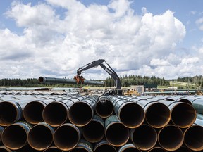 Pipes for the Trans Mountain pipeline is unloaded in Edson, Alta. on Tuesday June 18, 2019. THE CANADIAN PRESS/Jason Franson