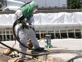 Coco Paving employee Nathan Vercouteren sandblasts the concrete deck of this bridge, located on the east lanes of Highway 401 near Dillon Road in Chatham-Kent on Thursday July 11, 2019. This work is part of the first phase of a multi-year rehabilitation project that includes pavement reconstruction, bridge rehabiltation and the installation of high-tension cable barriers. (Ellwood Shreve/Postmedia Network)