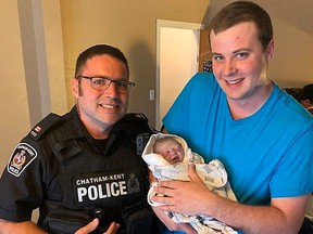 Chatham-Kent police Const. Gary Orient experienced a first in his policing career so far when he helped deliver a baby on Tuesday. The officer is pictured with the proud father and his daughter, whose names have not yet been released. Handout/Postmedia Network