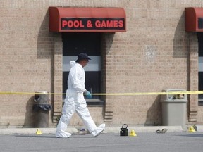 Peel Regional Police forensic officers work at the scene of a fatal shooting Monday outside Fume Bar and Lounge in Mississauga. (Ernest Doroszuk/Postmedia Network)