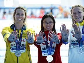 Women's 100m butterfly gold medallist Maggie MacNeil of London, silver medallist Sarah Sjoestroem of Sweden and bronze medallist Emma McKeon of Australia pose at the FINA world swimming championships in Korea.