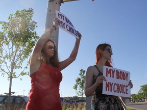 Debbie Taylor, left, and Olivia DeWolf protest the screening of Unplanned, a movie critics call anti-abortion propaganda, on Fanshawe Park Road. The movie is screening at London's SilverCity for a week. (Sebastian Bron/The London Free Press)
