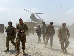 (FILES) In this file photo taken on August 12, 2015 US army soldiers walk as a NATO helicopter flies overhead at coalition force Forward Operating Base (FOB) Connelly in the Khogyani district in the eastern province of Nangarhar. - President Donald Trump has decided to pull a significant number of troops from Afghanistan, a US official told AFP on Thursday, a day after he announced a withdrawal from Syria. "That decision has been made. There will be a significant withdrawal," the official told AFP on condition of anonymity.