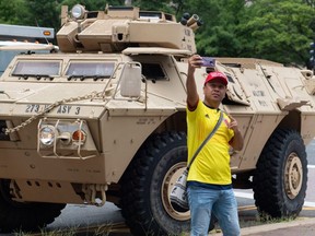 A man takes a photo near an armored military vehicle during the Fourth of July parade in Washington, DC, July 4, 2019.A Humvee is parked on a street in Washington, DC, on July 4, 2019. - Tanks in the heart of Washington, fighter jets screaming overhead, and a speech from the Lincoln Memorial: President Donald Trump has promised the "show of a lifetime" Thursday as he turns the Fourth of July into a personal primetime extravaganza. (Photo by SAUL LOEB / AFP)