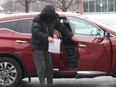 Claude Eric Trachy, seen in this file photo, keeps his face hidden from view when arriving at the Chatham Court House in Chatham, Ont., for his trial in April 2018. Postmedia Network