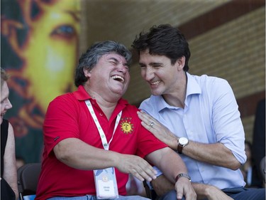 Prime Minister Justin Trudeau cracks up Sunfest executive artistic director Alfredo Caxaj during the opening ceremonies of the world music festival in Victoria Park in London on Thursday. Caxaj founded the festival 25 years ago. (Derek Ruttan/The London Free Press)