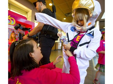 Sarah Topping helps seven-year-old Lily Rowe into a space suit at a STEM camp at Fanshawe College Friday. Mattel Toys gave astronaut Barbies to all the participants, who then got to watch as a Barbie was launched 40 kilometres into space via a helium weather balloon in London. (Mike Hensen/The London Free Press)