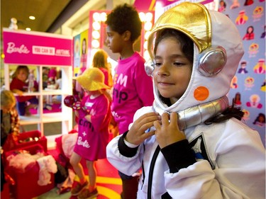Beatriz Santos adjusts her helmet as she tries on a space suit at a STEM camp at Fanshawe College Friday. Mattel Toys gave astronaut Barbies to all the participants, who then got to watch as a Barbie was launched 40 kilometres into space via a helium weather balloon in London. (Mike Hensen/The London Free Press)