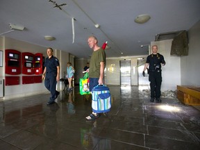 Tim Russell passes by emergency crews as he exits his apartment building at 940 Commissioners Rd. E. after a large sprinkler pipe started flooding the building's first three floors.  Photograph taken on Wednesday July 10, 2019.  Mike Hensen/The London Free Press/Postmedia Network