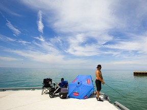 Brenden Fleming fishes for perch off the pier in Bayfield on a bright sunny summer day on Lake Huron. Mike Hensen/The London Free Press/Postmedia Network