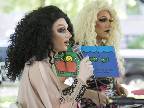 Miss Shaneen (left) and Nicki Nastasia read children's books during Drag Queen Story Time on the South Stage at the Home County Music and Art Festival in London, Ont. on Sunday July 21, 2019. Here Miss Shaneen is reading a book titled "It's Okay To Be Different." Derek Ruttan/The London Free Press/Postmedia Network