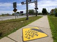 Train warning signs are painted on the sidewalks leading to the Colborne Street CN Rail crossing in London.  (Mike Hensen/The London Free Press)