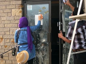 Members of the Owen Sound Muslim Association clean mustard off the front door of their mosque on Saturday morning after it was hit by vandalism for the second night in a row.