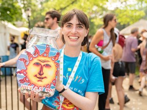 Sunfest volunteer Cameron Danis holds a donation jar by the Stingray Stage on Saturday.