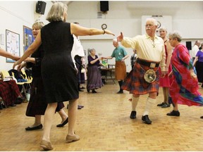 Tessa Catton and John Barker, with the Sarnia Scottish Country Dancers Association, reach toward one another dancing to Ferguson’s Fancy. The London Scottish dancers are holding three introductory nights in September. No experience or partner are required, only soft shoes. (Tyler Kula, Postmedia Network)