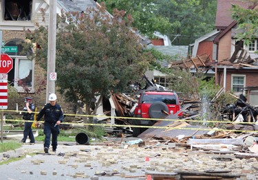 Emergency crews remained on the scene Thursday, Aug. 15, 2019, at Woodman Avenue, where a vehicle crashed into a home, causing an explosion that injured seven and damaged at least 10 homes. DALE CARRUTHERS / THE LONDON FREE PRESS