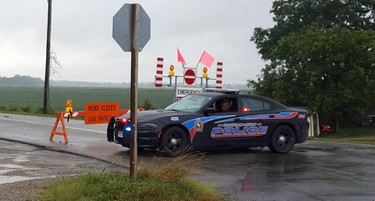 A police cruiser remains parked next to a "road closed" sign in the Erie Shores Drive area of Chatham-Kent. A state of emergency was declared for the Erie Shore Drive area on Tuesday. (Trevor Terfloth/The Daily News)