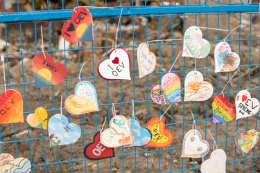 Decorated hearts hang from the blue fence that blocks off homes on Woodman Avenue that were damaged or destroyed in an explosion two weeks ago. (Max Martin, The London Free Press)