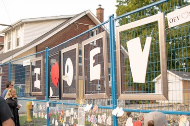 Decorated hearts hang from the blue fence that blocks off homes on Woodman Avenue that were damaged or destroyed in an explosion two weeks ago. (Max Martin, The London Free Press)