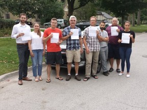 Old North residents Lee Metcalfe, left, Brooke Sveinbjornson, Chris Williamson, Frank Lahti, Andrew Botterell, James Haldane, Jesse Bielak and Samantha Bax are upset with city hall's parking-pass policy, made worse by a letter they received from city with an error about the policy. (DAN BROWN, The London Free Press)
