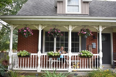 Nancy Pym enjoys a morning coffee on her porch, a charmer for passing motorists on Colonel Talbot Road, on the edge of Lambeth. The pretty impatiens pots and other garden enhancements are the handiwork of Pym as well as several wooden touches. She crafted the bench and 'welcome' sign, plus repainting an antique milk can. Pym and husband Skip have lived here 23 years, also sharing the home front with sons Jake and Tyson. (BARBARA TAYLOR The London Free Press)